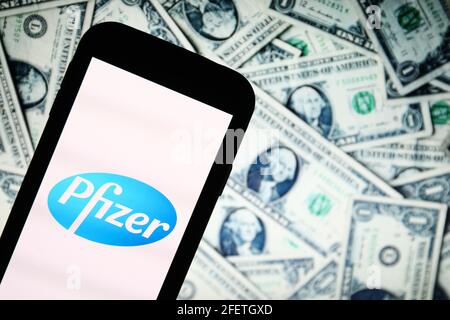 In questa illustrazione fotografica, un logo dell'app di Pfizer Pharmaceutical Company visualizzato su uno smartphone con bollette del dollaro sullo sfondo. (Foto di Filip Radwanski / SOPA Images/Sipa USA) Foto Stock
