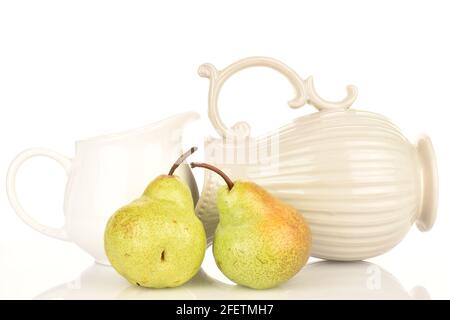 Due pere verdi succose, con caraffe in ceramica, primo piano, su sfondo bianco. Foto Stock