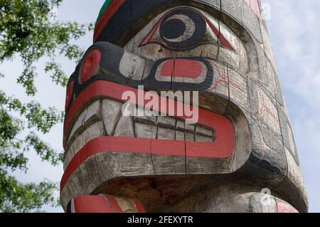 Rana sopra Bear Holding Seal - Carver: Richard Hunt 1988. Cowichan Valley, Vancouver Island, British Columbia, Canada. Foto Stock