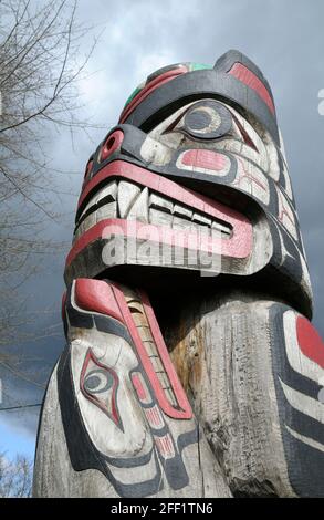 Rana sopra Bear Holding Seal - Carver: Richard Hunt 1988. Cowichan Valley, Vancouver Island, British Columbia, Canada. Foto Stock