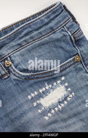 Jeans con un buco che sono stati dolcemente minacciati con stelle ricamate. Foto Stock