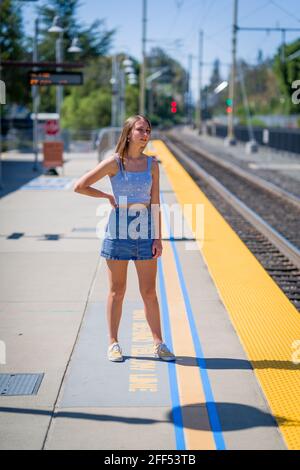 Dark Blonde Teen in attesa di un treno Foto Stock