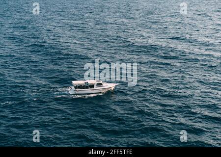 Il bianco yacht a motore veleggia in alto mare Foto Stock