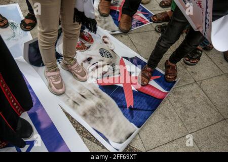 Gaza, Palestina. 24 Apr 2021. I manifestanti palestinesi hanno fatto un passo sulle foto del ministro della Difesa israeliano Benny Gantz e della bandiera israeliana a Khan Yunis, a sud della striscia di Gaza, durante una manifestazione anti-Israele sugli scontri notturni a Gerusalemme. (Foto di Yousef Masoud/SOPA Images/Sipa USA) Credit: Sipa USA/Alamy Live News Foto Stock