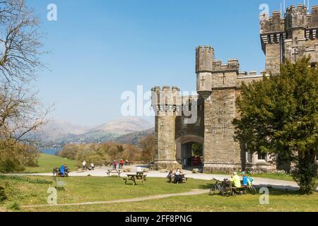Persone che siedono nei terreni di Wray Castle, Ambleside, Cumbria, Inghilterra, Regno Unito Foto Stock