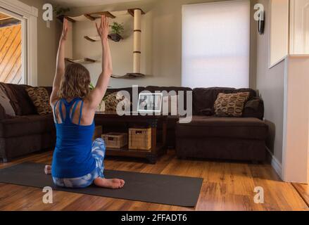 Istruzioni di yoga online nel comfort di casa tua. Mantenere la forma fisica e la flessibilità a proprio piacimento. Foto Stock