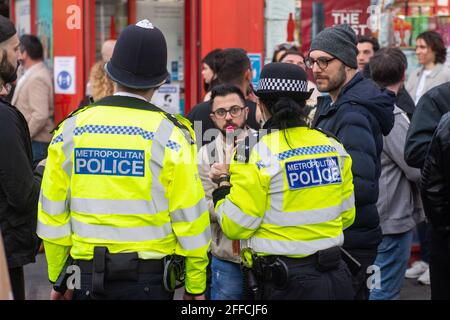 La polizia parla con la gente il sabato sera a Soho, nel centro di Londra, dopo l'ulteriore allentamento delle restrizioni di blocco in Inghilterra. Data immagine: Sabato 24 aprile 2021. Foto Stock