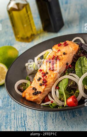 insalata di salmone verde e sana in piatto nero Foto Stock