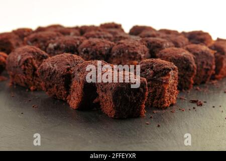 Torta brownie al cioccolato su ardesia nera su sfondo bianco Foto Stock