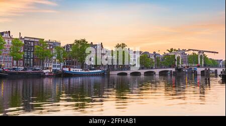 Amsterdam strade e canali durante il tramonto. Ponti illuminati, stagione estiva. Meta turistica popolare. Foto Stock
