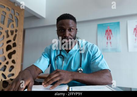 African american maschio medico alla scrivania che parla e gesturing durante consultazione videochiamata Foto Stock