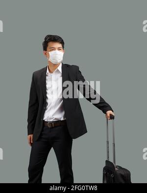 Nuovo stile di vita normale, uomo d'affari che viaggia e indossa maschera facciale proteggere il coronavirus covid-19 Foto Stock