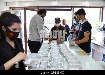 Tunisi, Tunisia. 24 Apr 2021. I volontari tunisini si preparano a distribuire gratuitamente i pasti di Iftar ai meno privilegiati durante il mese santo di digiuno musulmano del Ramadan presso l'Ariana, vicino a Tunisi. UN ristorante nel distretto di Ariana riceve aiuti dagli abitanti (uno dei distretti della classe operaia di Tunisi), Distribuisce un pasto gratuito di Iftar a più di 200 poveri tunisini e immigrati africani durante il santo mese di digiuno dei musulmani del Ramadan. Credit: SOPA Images Limited/Alamy Live News Foto Stock