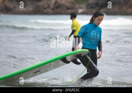 Galizia, Spagna - 2 agosto 2020: Lezioni di surf sulla spiaggia di San Antonio, Espasante. Surfisti principianti, imparando con le loro tavole da surf in una giornata nuvolosa, Foto Stock