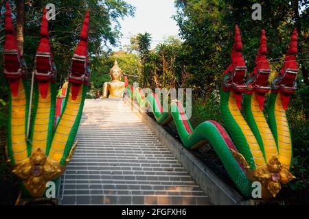 Grande statua del Buddha color oro all'aperto sulla cima della collina dell'isola di Prayam nella provincia di Ranong, Thailandia. Foto Stock