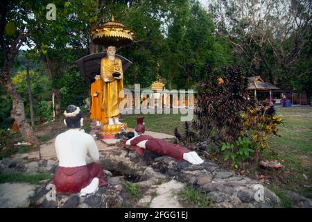 Statue di monaci che camminano elemosine in file di arte birmana ma custodite in templi thailandesi. Foto Stock