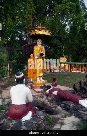 Statue di monaci che camminano elemosine in file di arte birmana ma custodite in templi thailandesi. Foto Stock