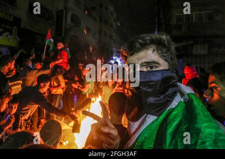 Gaza, Palestina. 24 Apr 2021. I palestinesi cantano slogan mentre bruciano le gomme durante un rally a sostegno della moschea al-Aqsa nella città di Gaza. I palestinesi hanno infuriato ieri sera a Gerusalemme occupata per l'undicesima notte di fila in protesta contro la polizia israeliana e le provocazioni e gli assalti dei coloni ai residenti della città, e si sono espansi per raggiungere la Cisgiordania e la striscia di Gaza. Credit: SOPA Images Limited/Alamy Live News Foto Stock