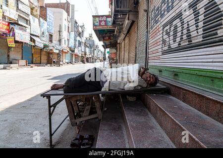 un uomo non identificato che dorme sulla strada durante il blocco in india. Foto Stock