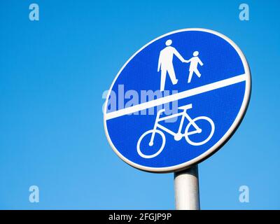 Percorso diviso per ciclisti e pedoni segnaletica stradale blu, dettaglio oggetto, closeup, isolato su sfondo blu cielo. Cartelli della città, simboli, strada condivisa fo Foto Stock