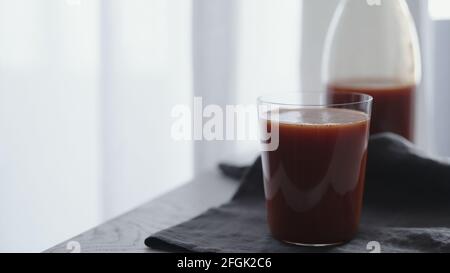 succo di pomodoro in bicchiere da bicchiere su tela di lino, foto ampia Foto Stock