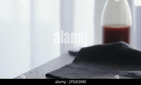 panno di lino con succo di pomodoro in vetro su sfondo, foto ampia Foto Stock