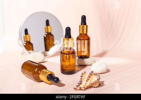 Set di siero per il viso in flaconi di vetro con pipetta, cosmetici naturali biologici per il centro benessere. Concetto di cura della pelle - immagine Foto Stock