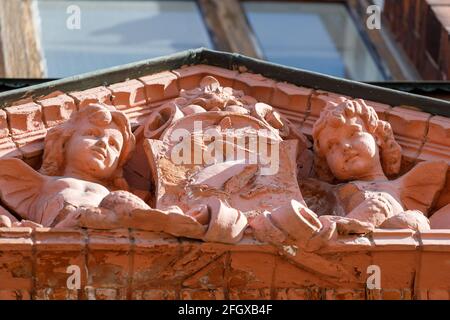 bassorilievo con angeli rossi sulla facciata dell'edificio. Foto di alta qualità Foto Stock