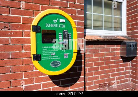 Defibsafe 2, un defibrillatore pubblico o un dispositivo di avviamento cardiaco in un armadietto esterno protetto da tastiera, per emergenze salvavita, su una parete del Regno Unito. Foto Stock