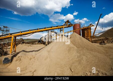 Assemblaggio dell'impianto di frantumazione delle rocce. Macchina per la separazione di ghiaia che utilizza per la triturazione di minerali d'oro. Cumulo di terreno sulla parte anteriore. Regione di Almaty, Kazakistan Foto Stock