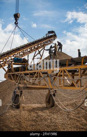 Miniere e lavorazioni plant.workers assemblaggio macchina frantumatrice roccia per oro minerale shredding.lifting da gru.cielo blu, Nubi.Almaty regione, Kazakstan. Foto Stock