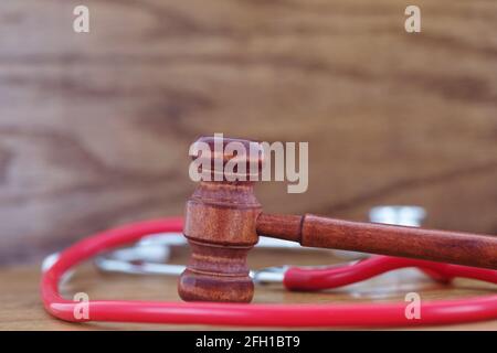 Gavel e stetoscopio si combinano come simboli di giustizia ed equità nell'assistenza sanitaria e nell'assistenza degli anziani nell'immagine di concetto di questioni sociali moderne Foto Stock