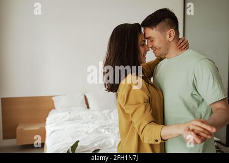 Felice giovane coppia è abbracciando e mostrando i loro sentimenti. Bella famiglia che si sposta in nuovo appartamento Foto Stock