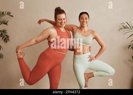 Le donne sportive si levano in piedi insieme su una gamba in studio di idoneità. Donne che si esercitano al club di salute. Foto Stock