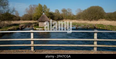 Longstock, Hampshire, Inghilterra, Regno Unito. Il River Test come scorre attraverso Longstock con una capanna di pesca con tetto di paglia e anguille trappole che attraversa questo famoso Chalkst Foto Stock