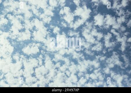 Piccole nuvole ariose su cielo blu Foto Stock