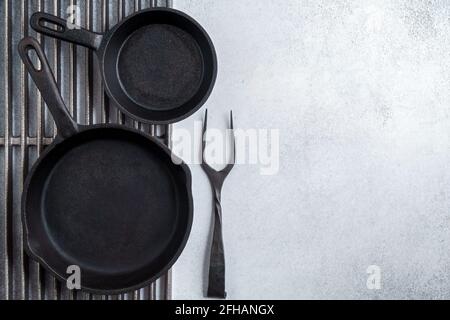 Coppia di padelle in ghisa su griglie e forcelle con spazio per la copia Foto Stock