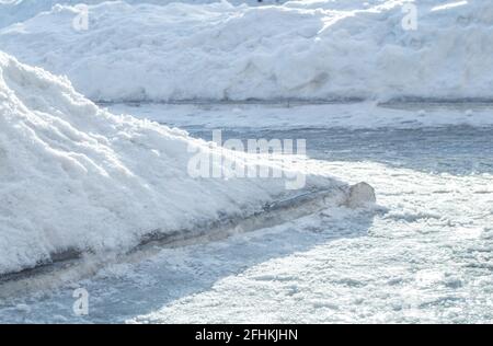 Grande deriva di neve dopo la pulizia del marciapiede, strada in città. Foto Stock