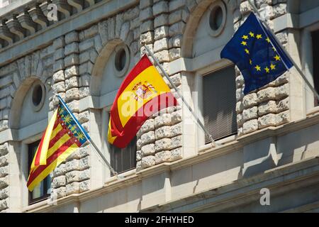 Bandiera sventolante della Spagna appesa al Regno di Spagna istituzioni e edificio amministrativo ad Alicante, Valencia, Spagna Foto Stock