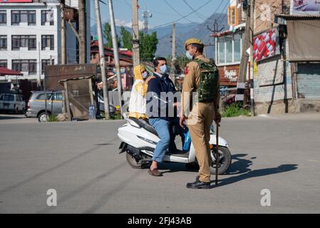 Srinagar, India. 25 Apr 2021. Un poliziotto indiano ferma un uomo su uno scooter durante un coprifuoco di un giorno per frenare la diffusione di COVID-19 a Srinagar.India ha riportato 346,786 nuovi casi di COVID-19 per le 24 ore precedenti, con 2,624 morti, il più alto numero di morti al mondo dal giorno della pandemia iniziata lo scorso anno. Complessivamente, nel paese sono morte quasi 190,000 persone a causa della COVID, mentre oltre 16.6 milioni sono state infettate. Credit: SOPA Images Limited/Alamy Live News Foto Stock