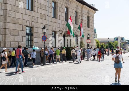 Budapest, Ungheria - 10 agosto 2019: Gruppo di turisti a piedi vicino a un edificio in stile ungherese nel centro di Budapest Foto Stock
