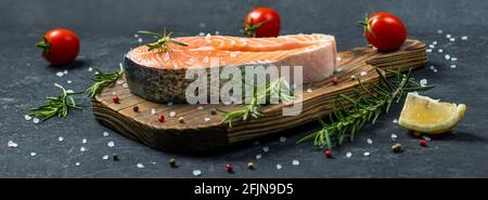 Bistecca di salmone con verdure e spezie su fondo di legno. Foto Stock