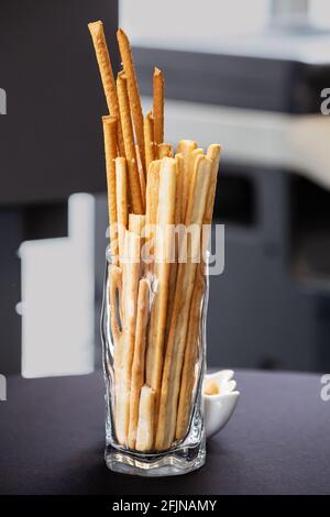 Bastoncini di pane in vetro trasparente sul tavolo da ufficio Foto Stock