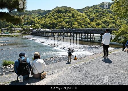 Osaka, Giappone. 25 Apr 2021. I pedoni che indossano maschere facciali camminano al Ponte di Togetsukyo a Kyoto, Giappone, domenica 25 aprile 2021. Le prefetture di Tokyo, Osaka, Kyoto e Hyogo sono entrate in un nuovo stato di emergenza per il COVID-19 dal 25 aprile al 11 maggio. Foto di Keizo Mori/UPI Credit: UPI/Alamy Live News Foto Stock