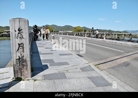 Osaka, Giappone. 25 Apr 2021. I pedoni che indossano maschere facciali camminano al Ponte di Togetsukyo a Kyoto, Giappone, domenica 25 aprile 2021. Le prefetture di Tokyo, Osaka, Kyoto e Hyogo sono entrate in un nuovo stato di emergenza per il COVID-19 dal 25 aprile al 11 maggio. Foto di Keizo Mori/UPI Credit: UPI/Alamy Live News Foto Stock