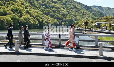 Osaka, Giappone. 25 Apr 2021. I pedoni che indossano maschere facciali camminano al Ponte di Togetsukyo a Kyoto, Giappone, domenica 25 aprile 2021. Le prefetture di Tokyo, Osaka, Kyoto e Hyogo sono entrate in un nuovo stato di emergenza per il COVID-19 dal 25 aprile al 11 maggio. Foto di Keizo Mori/UPI Credit: UPI/Alamy Live News Foto Stock