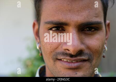 Un ritratto di un giovane maschio indiano sorridente che guarda la fotocamera Foto Stock