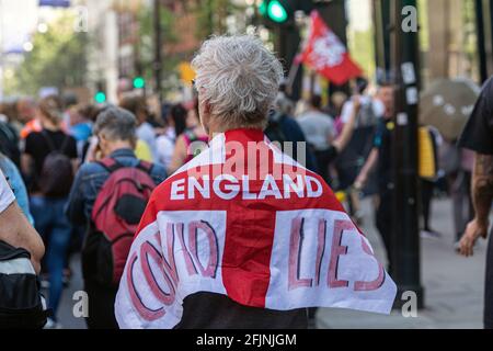 24 aprile 2021, Londra, Inghilterra, Regno Unito: L'uomo porta la bandiera di San Giorgio con scritto ' Covid Lies' durante un anti-blocco 'Unite per libero Foto Stock