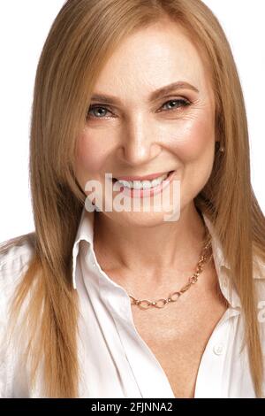 Ritratto di una bella donna anziana in una camicia bianca con trucco classico e capelli biondi. Foto Stock