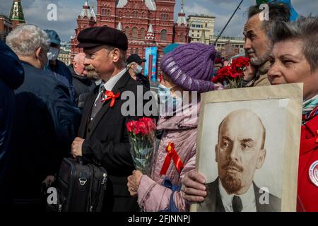 Mosca, Russia. 22 aprile 2021 UN uomo (a sinistra), che impersona il fondatore sovietico Vladimir Lenin, e altri sostenitori del partito comunista camminano per visitare il Mausoleo del fondatore sovietico Vladimir Lenin per celebrare il 151 ° anniversario della sua nascita, in Piazza Rossa nel centro di Mosca, Russia Foto Stock